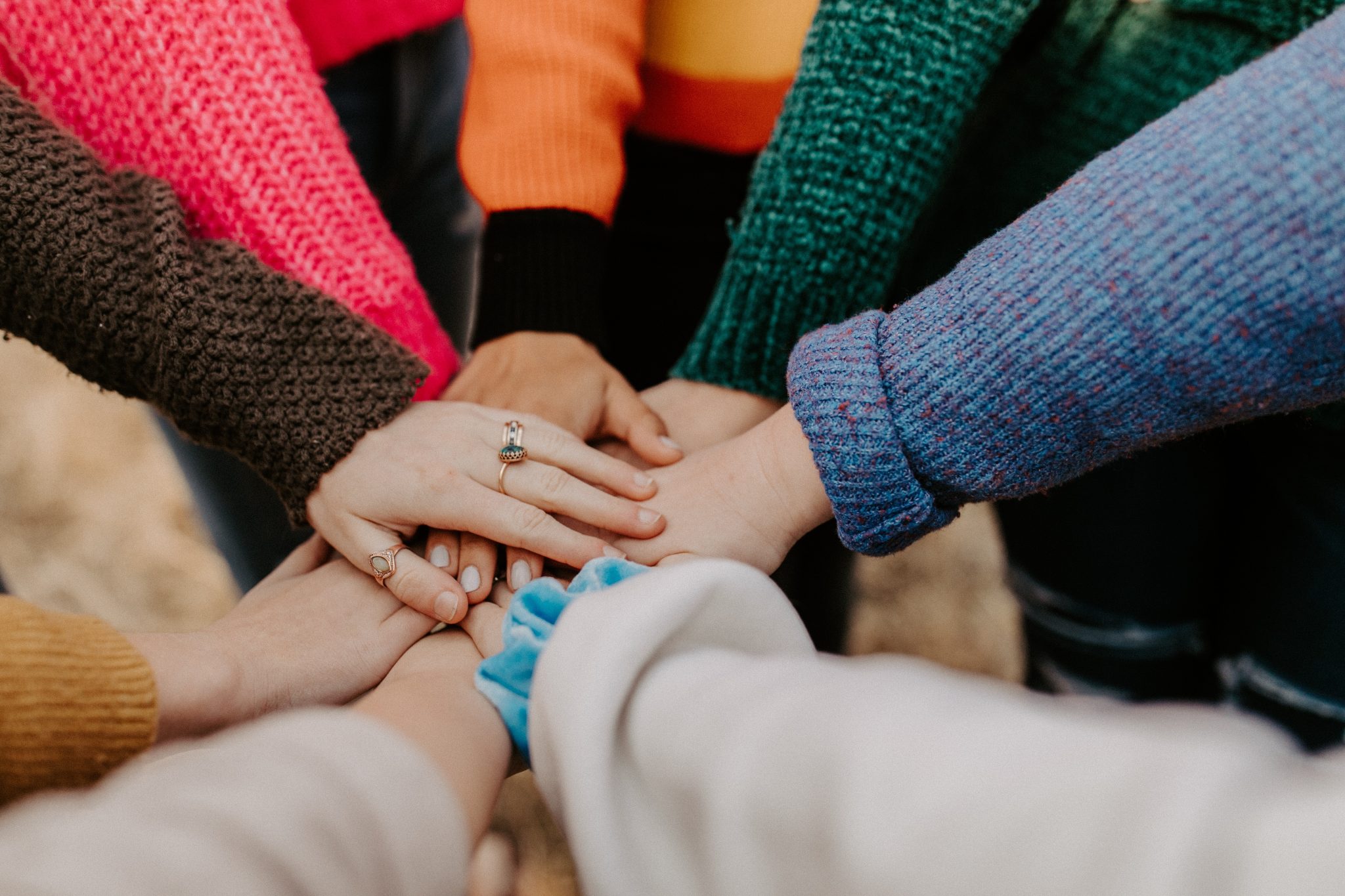 Many hands on top of each other in a circle.